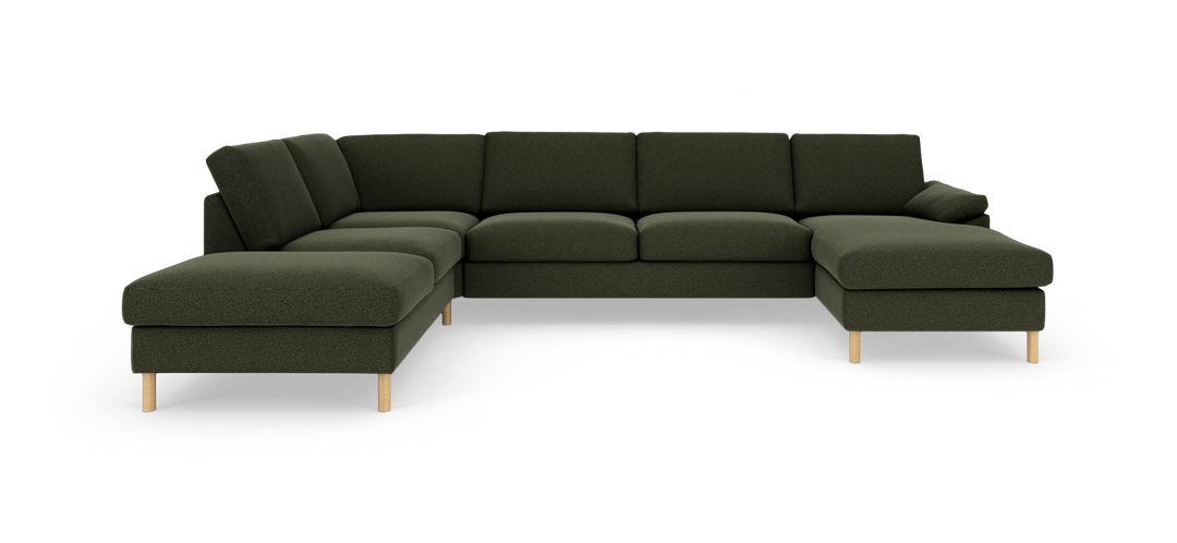 Mörkgrön modulsoffa i U-form med chaiselong i båda ändar och ljusa träben på vit bakgrund.