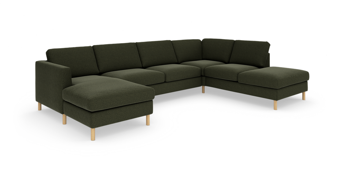 Modulsoffa i mörkgrönt tyg, U-soffa med schäslong på båda sidor och ljusa träben, frilagd mot vit bakgrund.