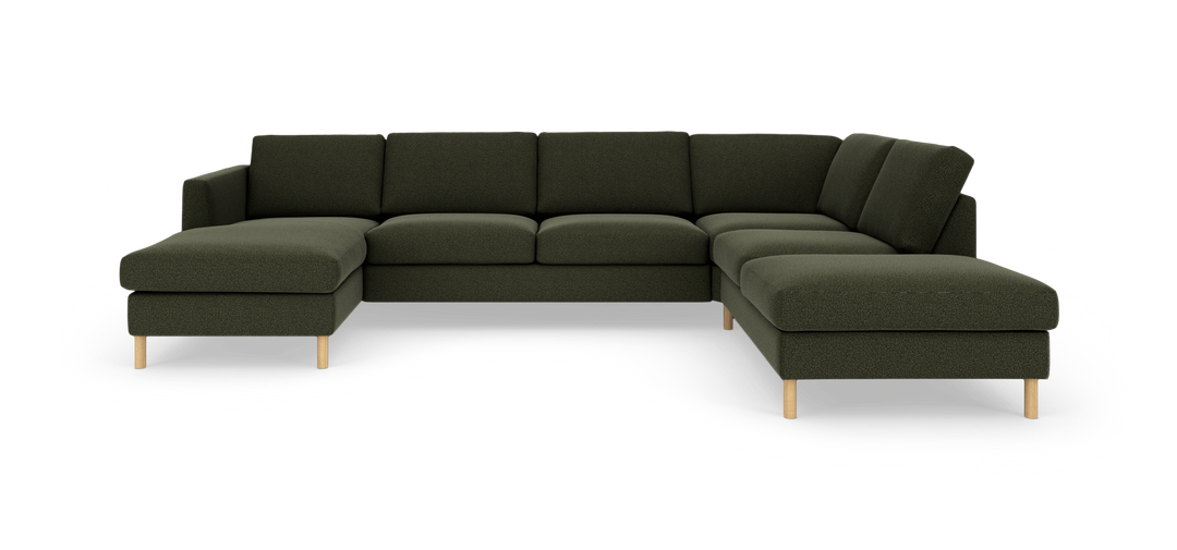 Mörkgrön modulsoffa i U‑form med schäslong till vänster och divan till höger, med ljusa träben.