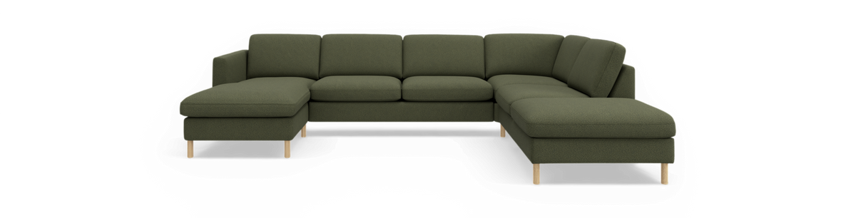 Grön modulsoffa i U‑form med schäslonger på båda sidor och träben, frilagd på svart bakgrund.