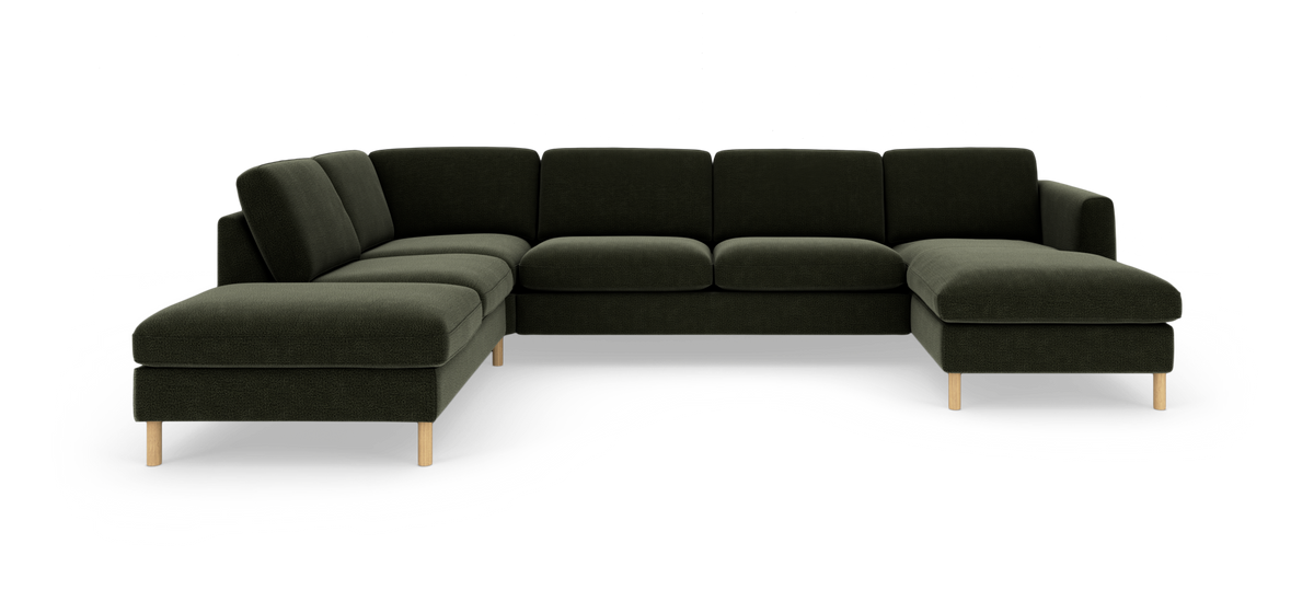 Mörkgrön modulsoffa i U‑form med schäslonger på båda sidor och ljusa träben, fotad rakt framifrån i studiobakgrund.