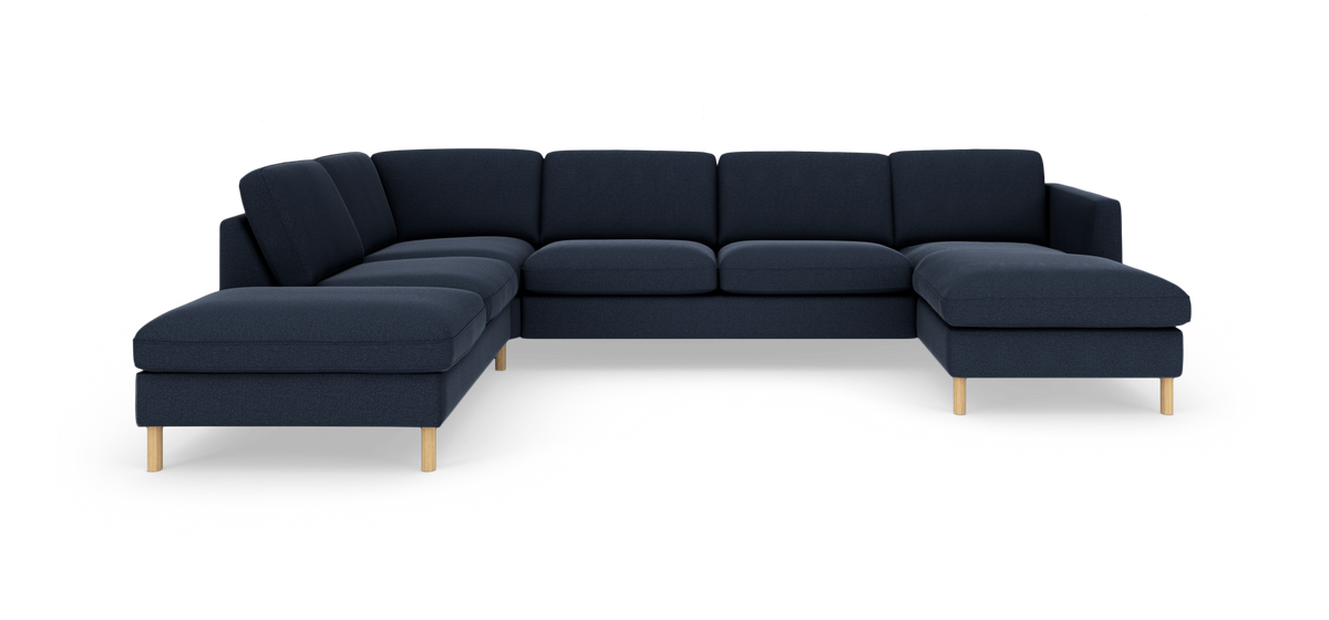 Mörkblå modulsoffa i U‑form med träben, frilagd i studiobelysning.