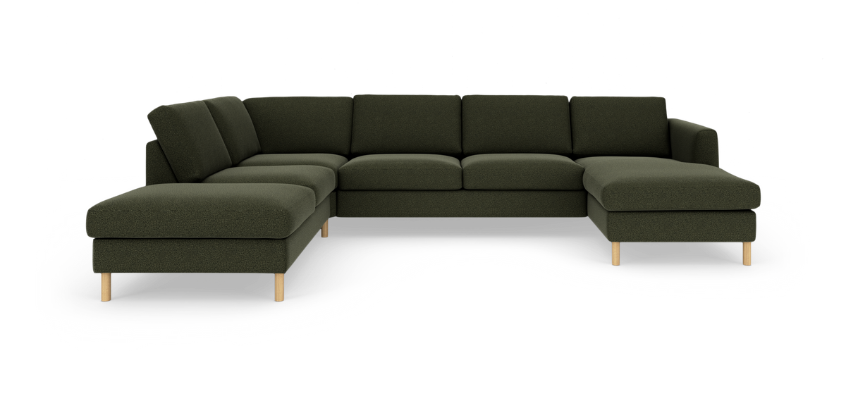Mörkgrön modulsoffa i U‑form med schäslonger på båda sidor och ljusa träben, frilagd på vit bakgrund.