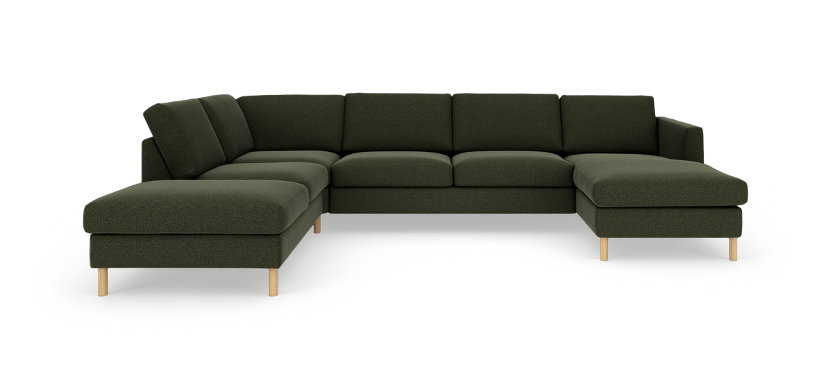 Mörkgrön modulsoffa i U‑form med schäslong på båda sidor och ljusa träben, frilagd på vit bakgrund.