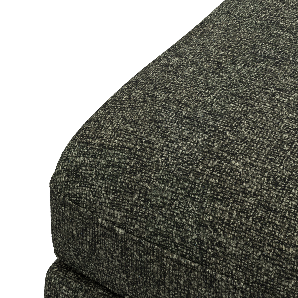 Närbild av mörk, grå‑grön texturerad klädsel på hörnet av en soffdyna.