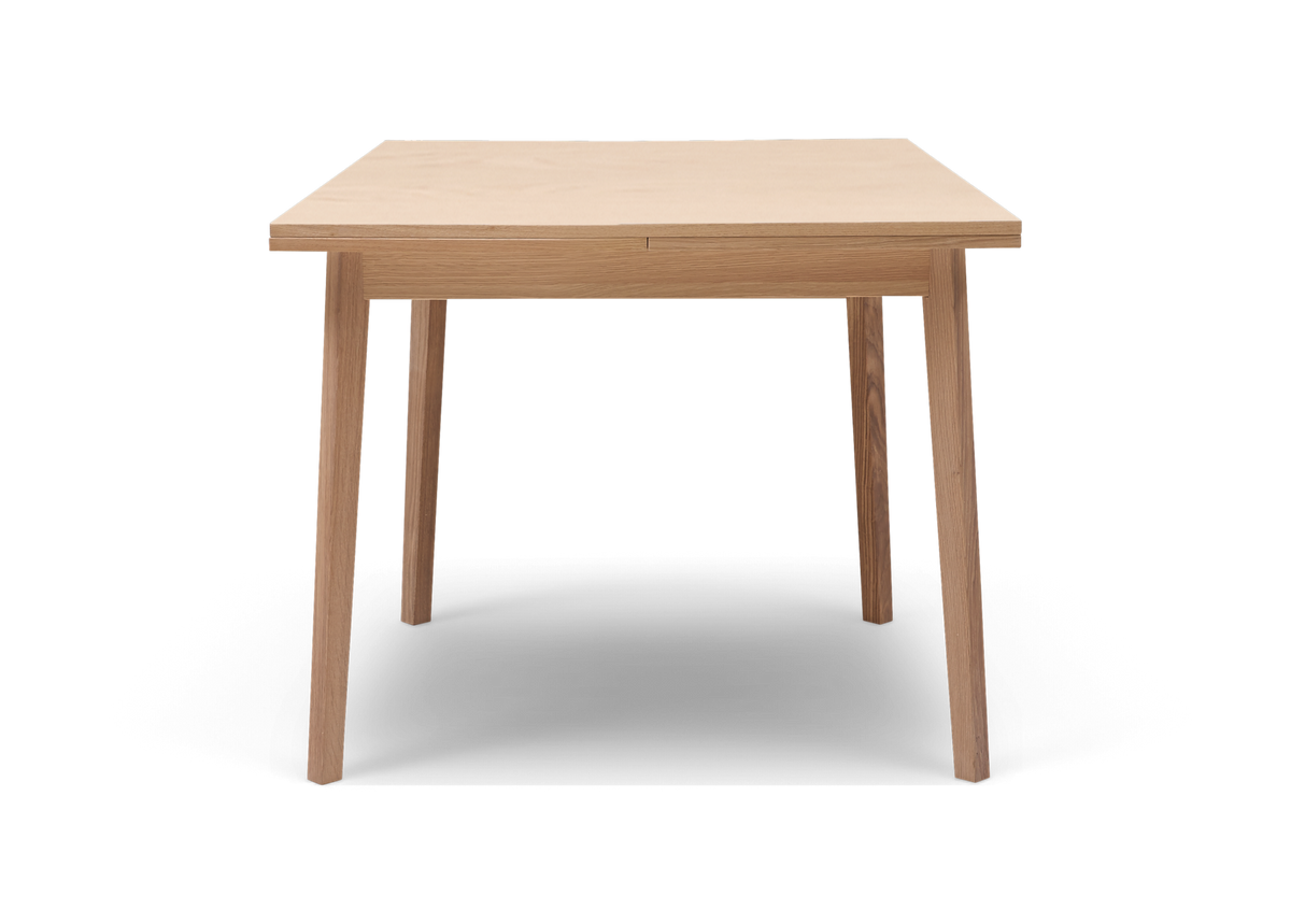 Framifrånvy av ett minimalistiskt matbord i ljus ek mot vit bakgrund.