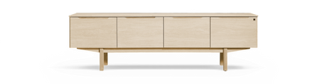 Ljus ek‑sideboard med fyra dörrar och höga ben, frilagd mot svart bakgrund.