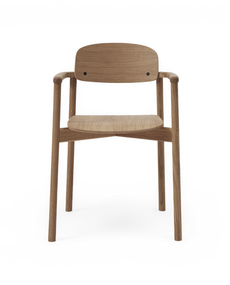 Minimalistisk karmstol i ek med rundad rygg och armstöd, frilagd framifrån.