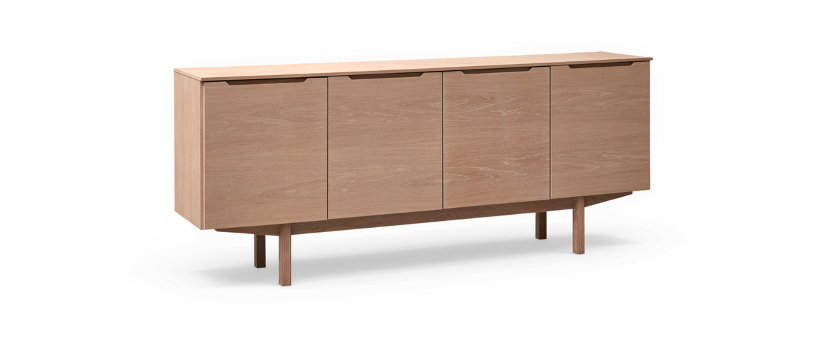 Låg sideboard i ljus ek med fyra dörrar och slanka ben.