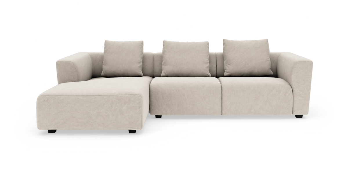 Beige modulsoffa med schäslong till vänster och tre ryggkuddar på vit bakgrund.