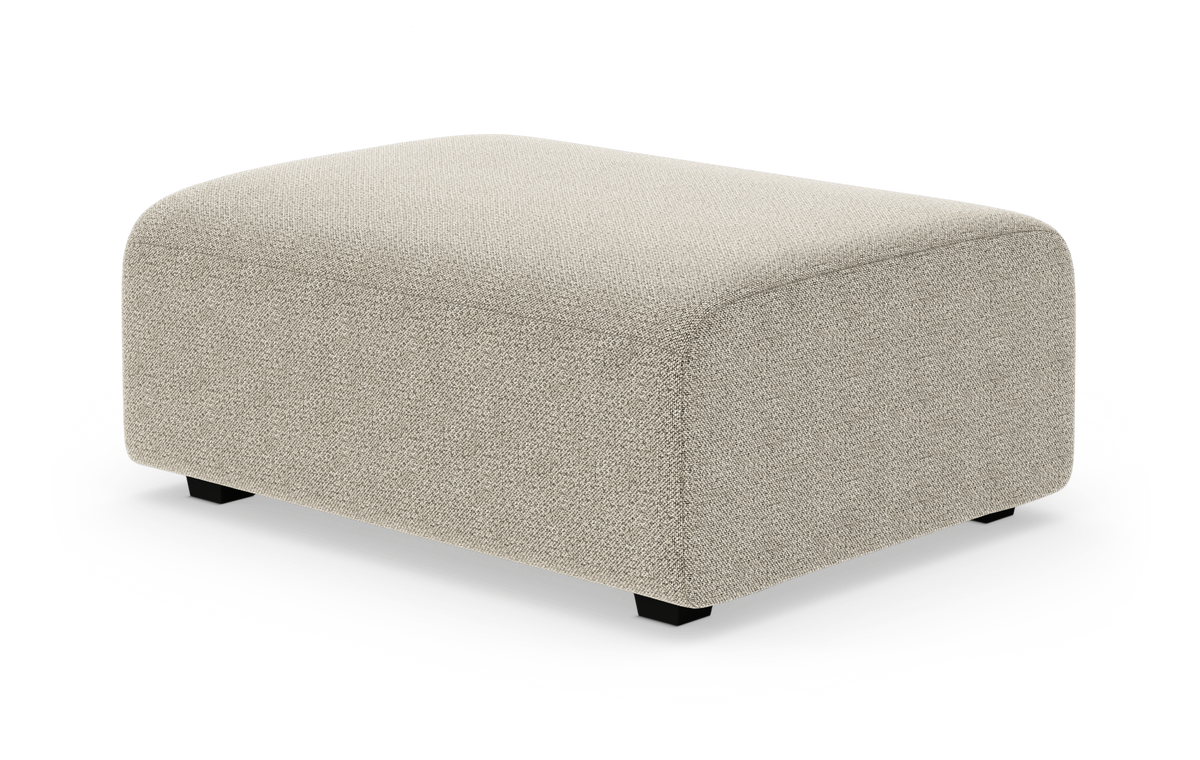 Beige fotpall/ottoman med mjuk textil och rundade hörn på vit bakgrund.