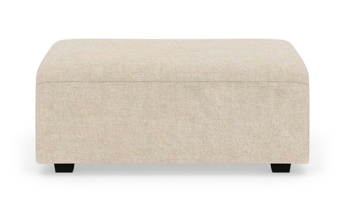 Beige rektangulär sittpuff/ottoman med låga svarta ben frilagd mot vit bakgrund.