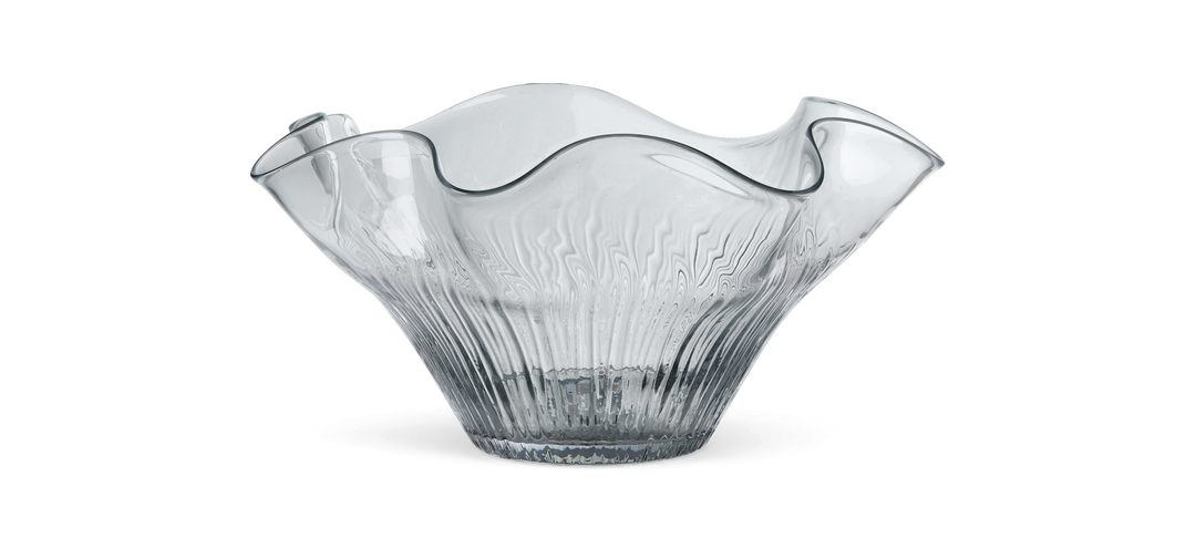 Vågkantad genomskinlig glasskål mot svart bakgrund.