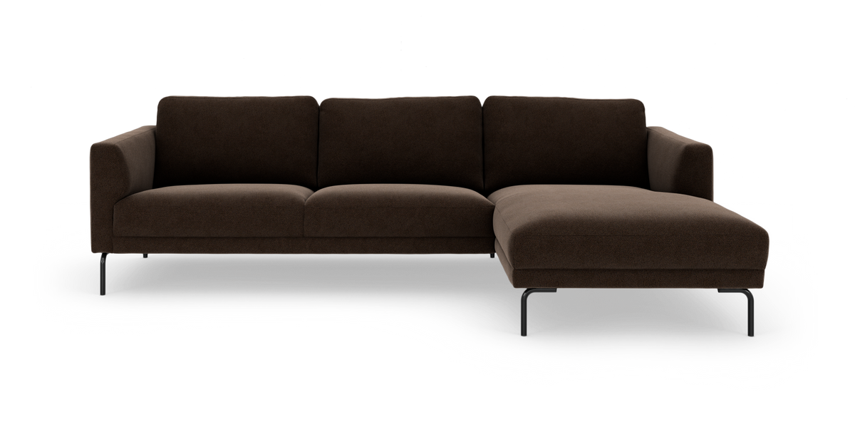 Mörkbrun modulsoffa med högervänd divan på slanka svarta metallben, frilagd på vit bakgrund.