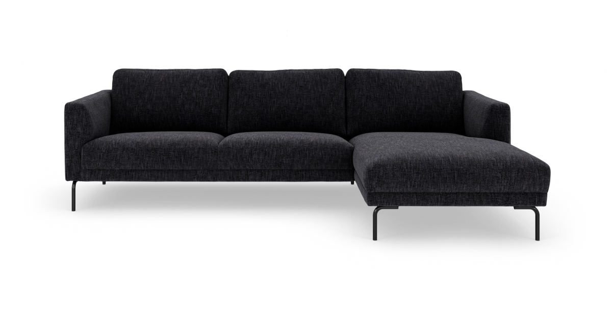 Mörkgrå, modern 3-sits hörnsoffa med schäslong på höger sida och slanka metallben, frilagd på vit bakgrund.