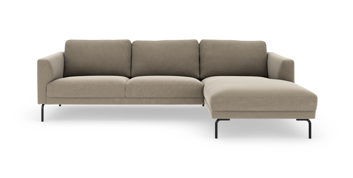 Modern beige hörnsoffa med schäslong till höger på svarta metallben, frilagd.