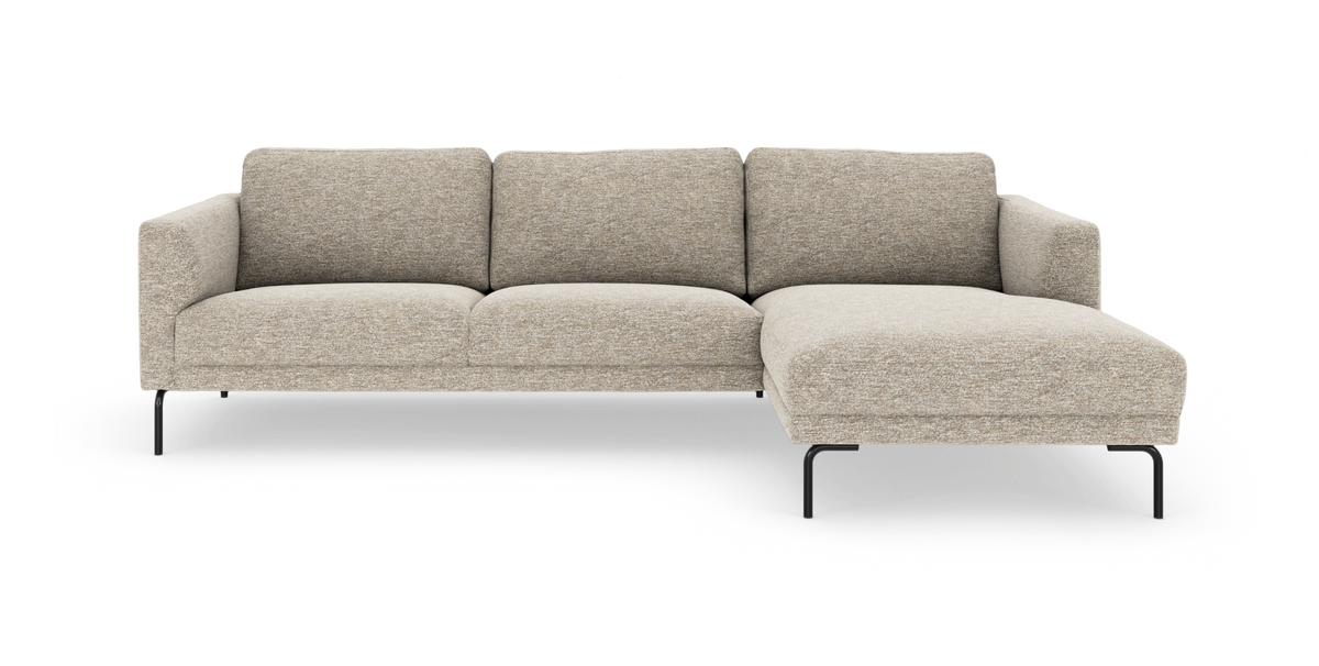 Beige L‑formad modulsoffa med schäslong till höger och svarta metallben, frilagd mot vit bakgrund.