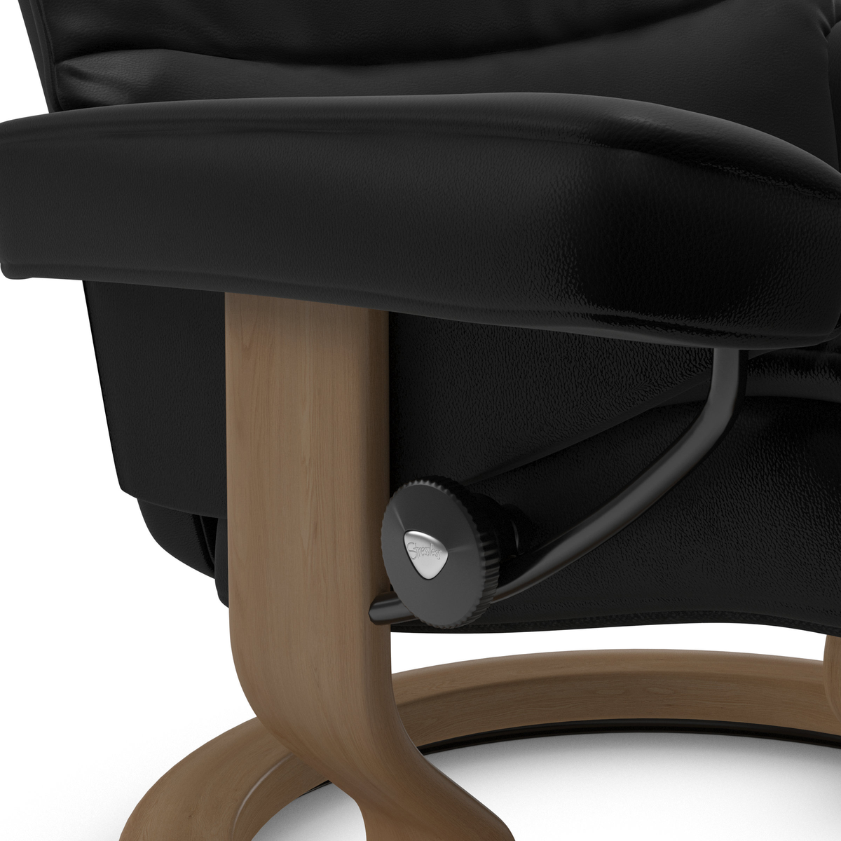 Närbild av svart läderfåtölj med träbas och Stressless justeringsratt i studiobelysning.