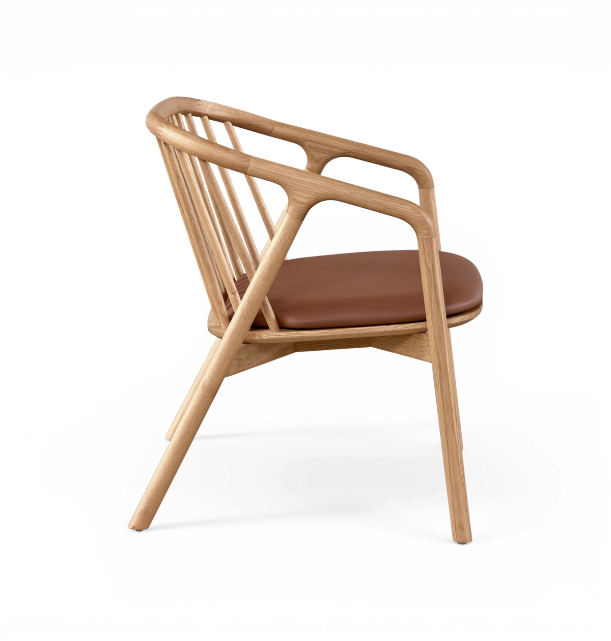 Modern karmstol i ljus ek med brun lädersits, sedd från sidan mot vit bakgrund.