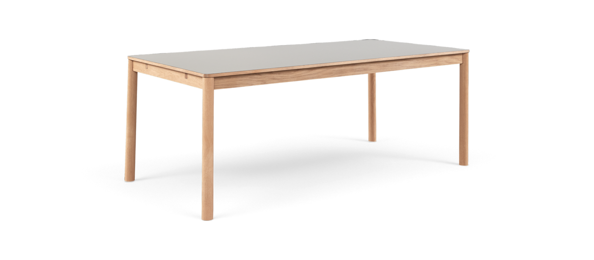 Rektangulärt bord med ljus bordsskiva och ben i ljust trä, minimalistisk design.