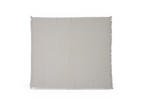 Ljusbeige pläd med diskreta fransar längs kanterna, platt utlagd mot vit bakgrund.