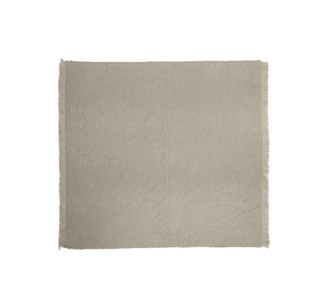Ljus skandinaviskt inredd vardagsrum‑och‑matplats med beige soffa, runt soffbord i trä, svart golvlampa, två inramade affischer, vas med pampasgräs, ljus matta, skira gardiner och träbord med svarta stolar under svart pendellampa.