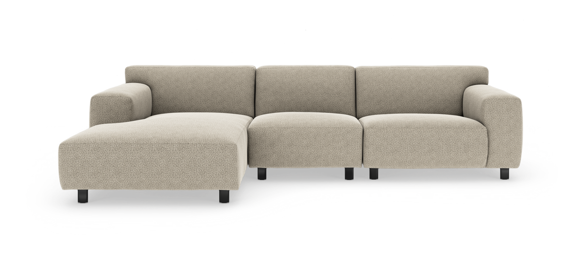 Beige modulsoffa med vänster schäslong, tre sittplatser och svarta ben, frilagd på vit bakgrund.