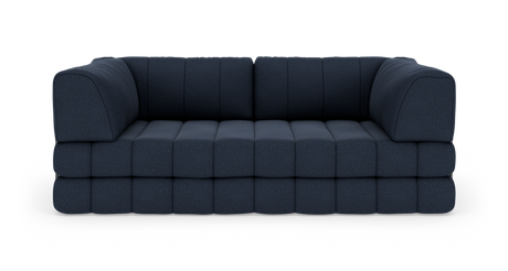 Mörkblå modulsoffa i tyg med quiltade, kubformade dynor – frontvy.