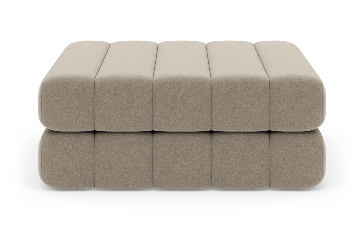 Beige modulär polstrad ottoman/pall i två lager, sedd framifrån mot vit studiobakgrund.