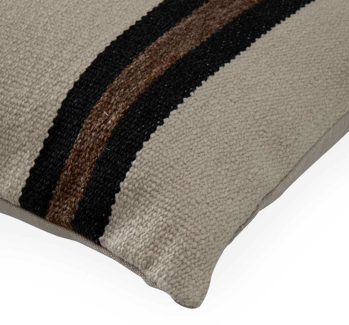 Beige kudde i grovt vävt tyg med två ränder i svart och brun, närbild med synlig dragkedja.