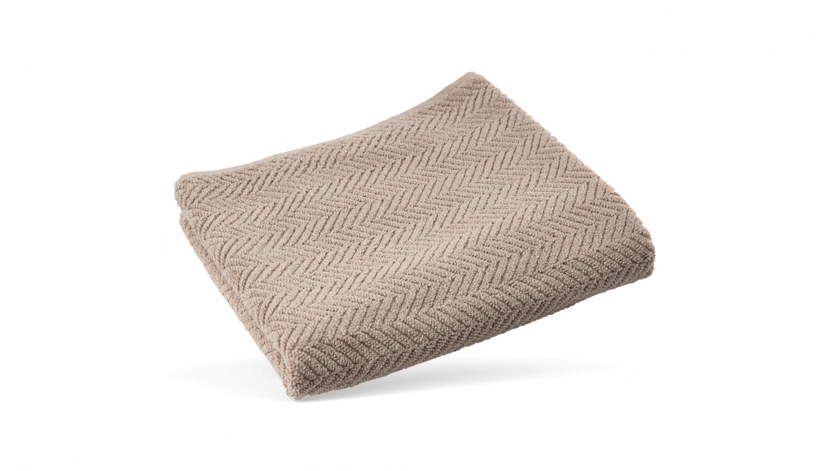 Hopvikt beige handduk med fiskbensmönster.
