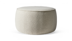 Beige rund puff i bouclétyg mot svart bakgrund.