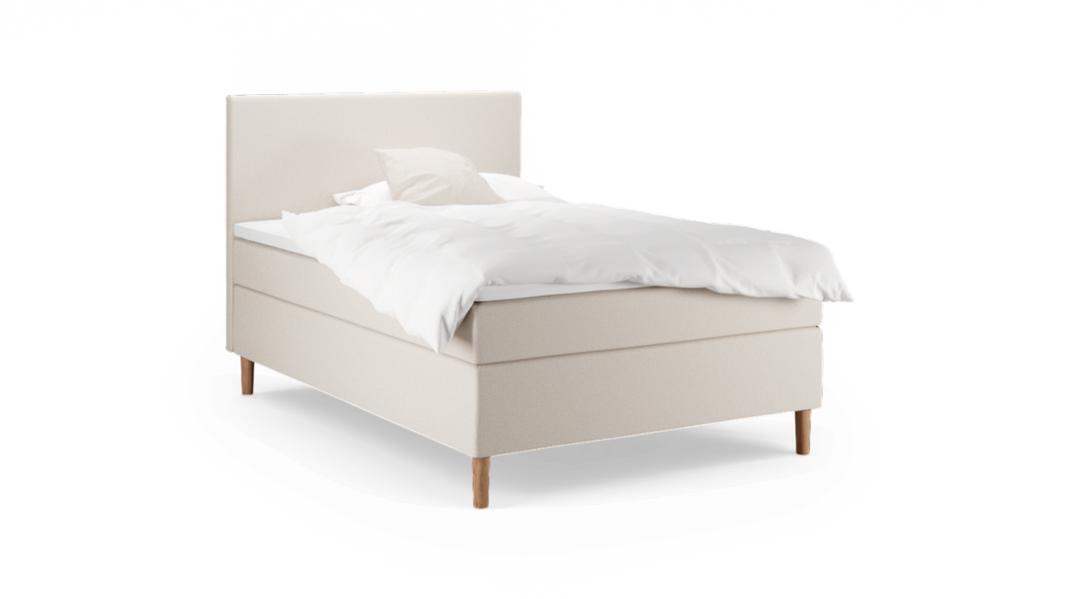 Beige stoppad enkelsäng med vit täcke och kudde, träben, frilagd mot svart bakgrund.