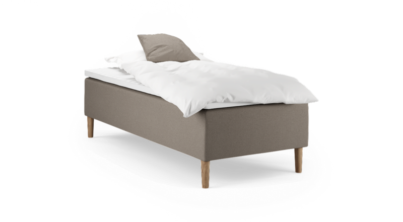 Enkel enkeltsäng med beige klädd sängbas, vit kudde och täcke samt träben, frilagd på vit bakgrund._ps