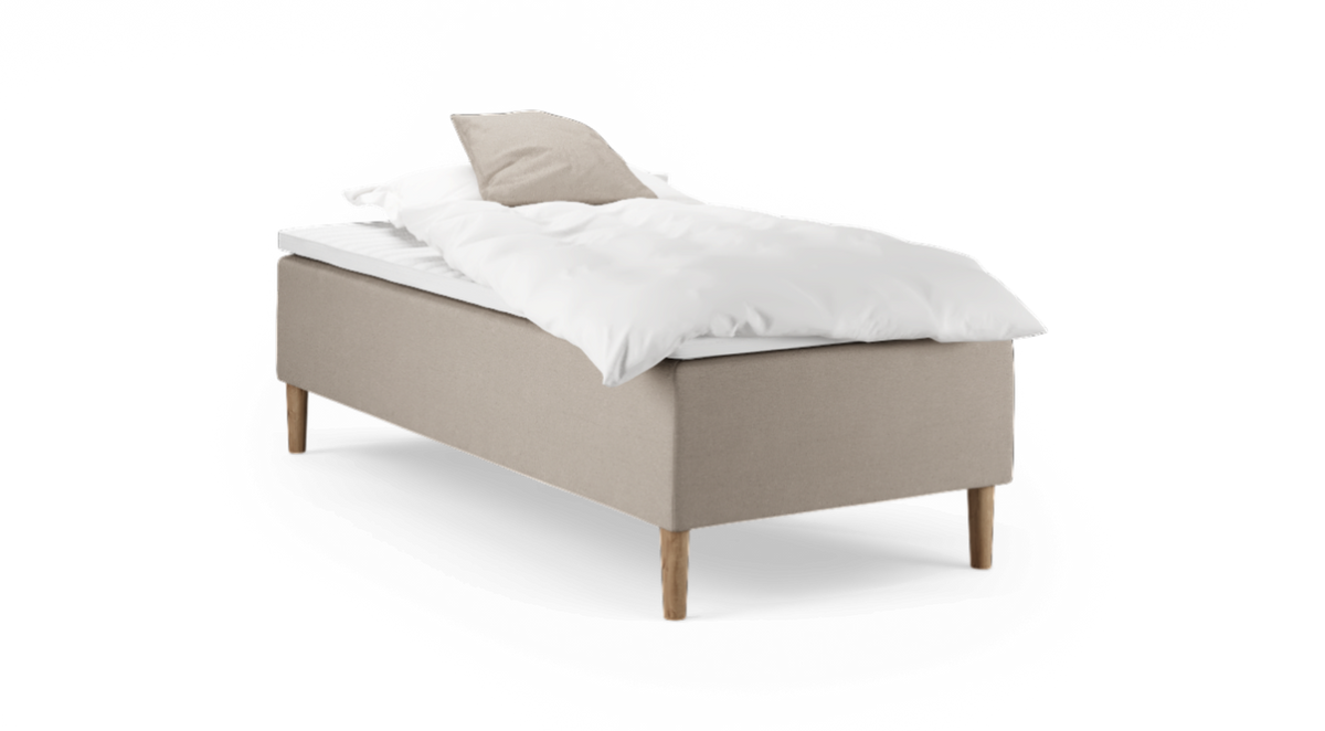 Enkel säng med beige sängram på träben, vit täcke och beige kudde, frilagd.