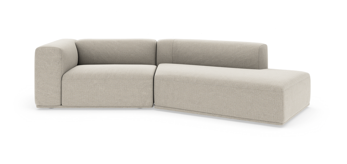 Beige modulsoffa i L‑form med hög rygg och rundade hörn, frilagd på vit bakgrund.