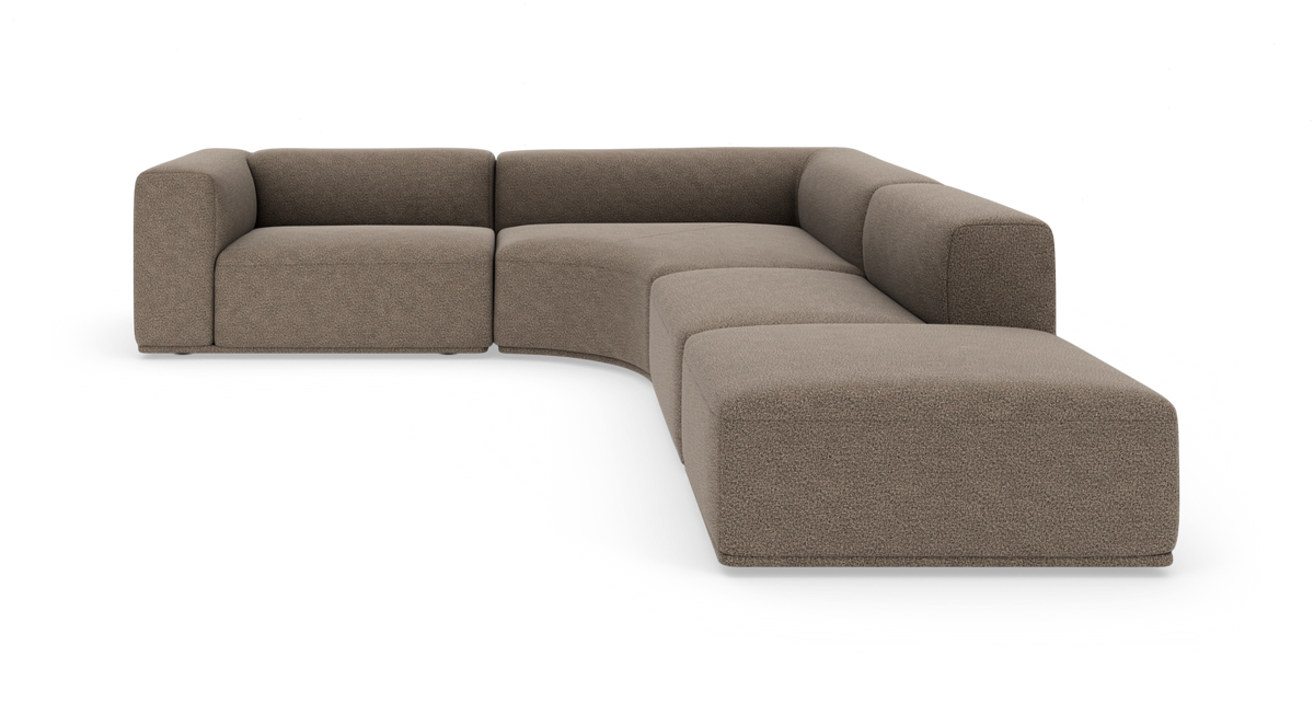 L-formad modulsoffa med böjd mittsektion i beige bouclé och breda armstöd, frilagd mot vit bakgrund.