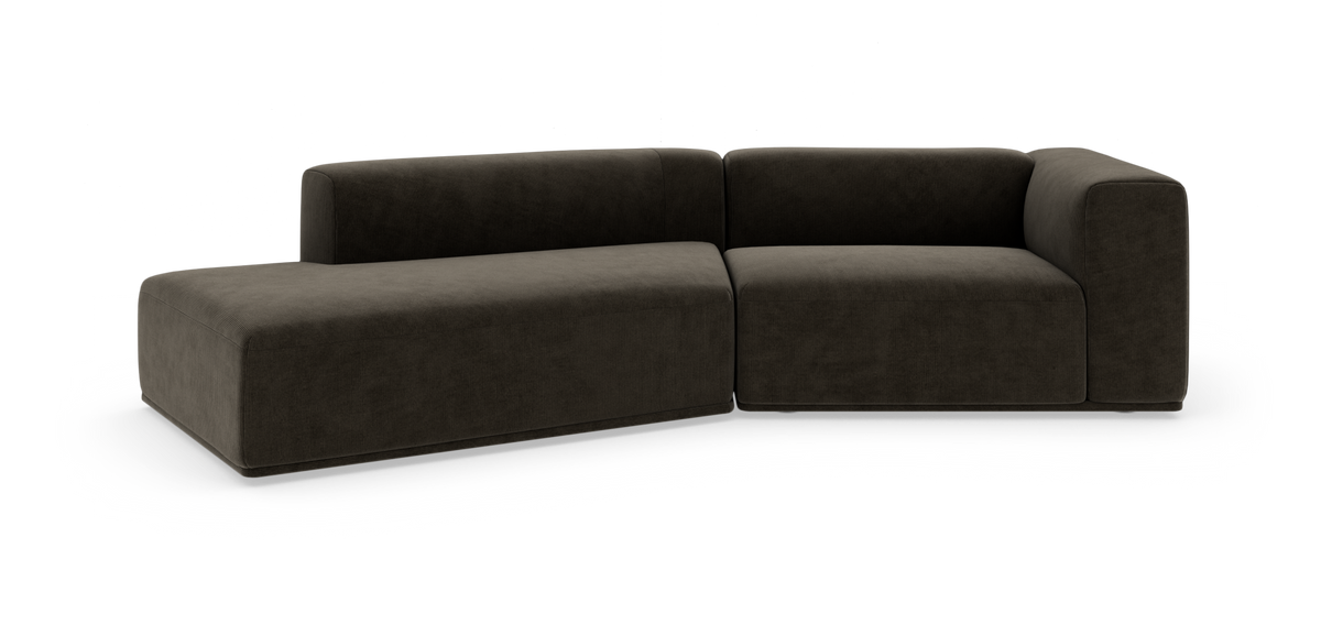Mörk, modulär L-formad soffa i tyg på vit bakgrund.