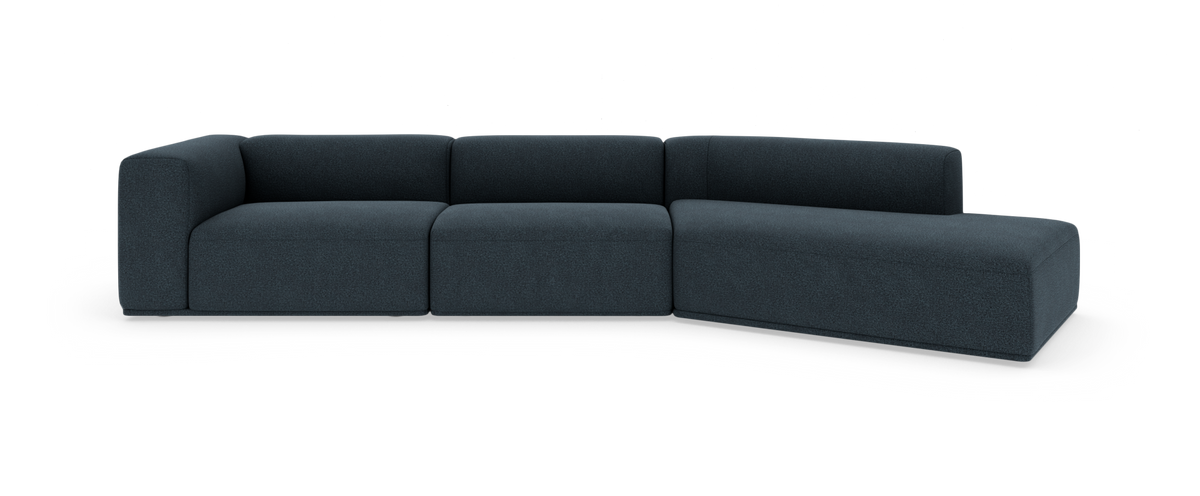 Modulsoffa i mörkblått tyg med högersvängd chaise, fristående mot vit bakgrund.